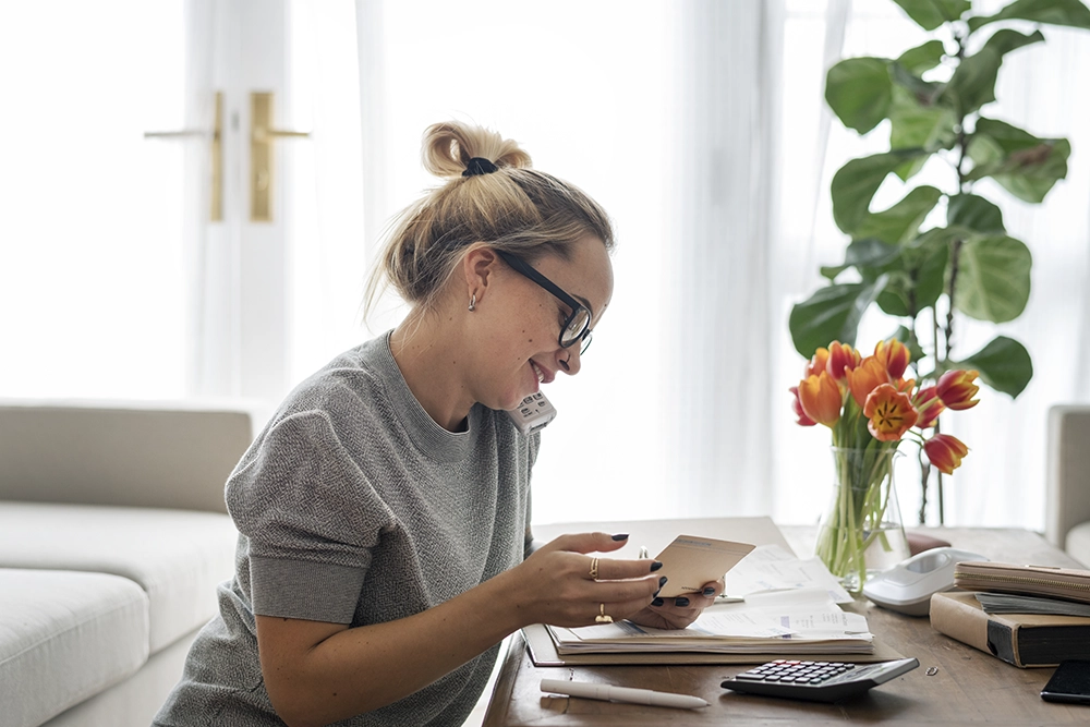 Femme occupée à téléphoner et à calculer