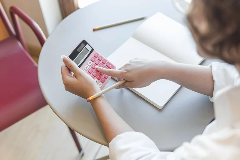 Une femme en train d'utiliser une calculatrice
