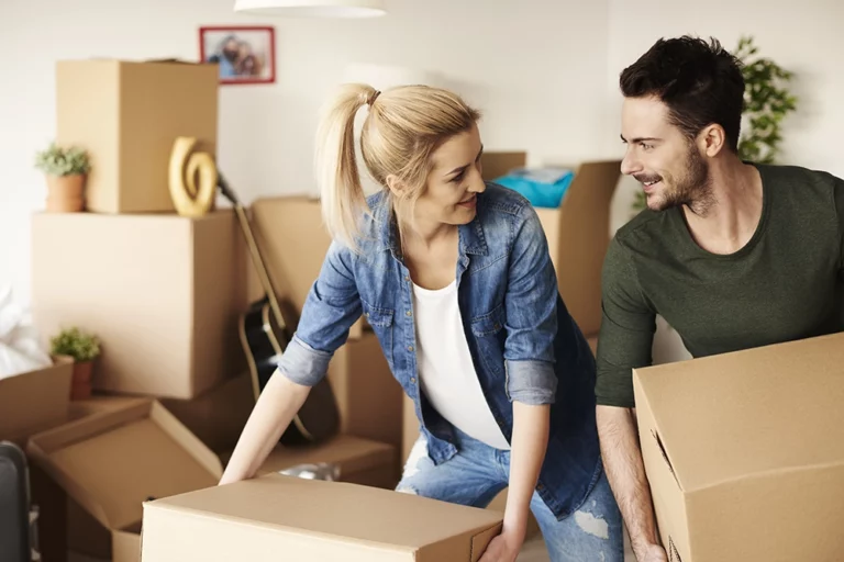 Couple heureux en train de déménager des cartons
